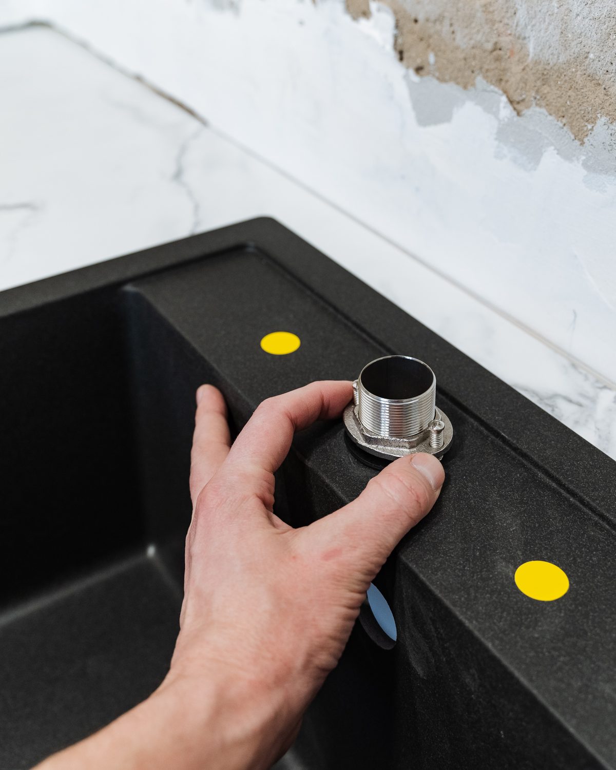 Chrome tap being assembled and fitted to a sink